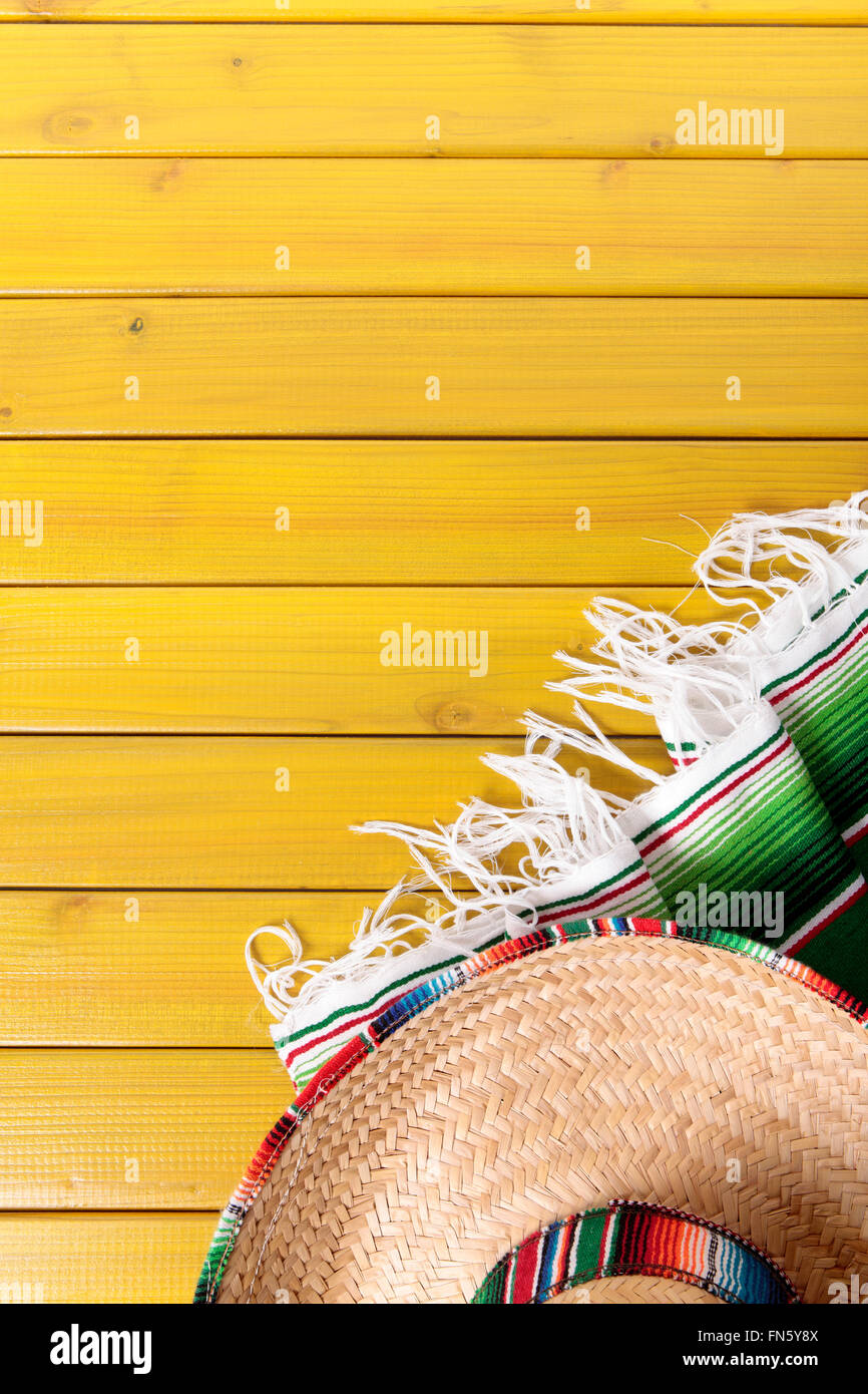 Sombrero messicano e tradizionale coperta serape prevista su un dipinto di giallo in legno di pino piano. Spazio per la copia. Foto Stock