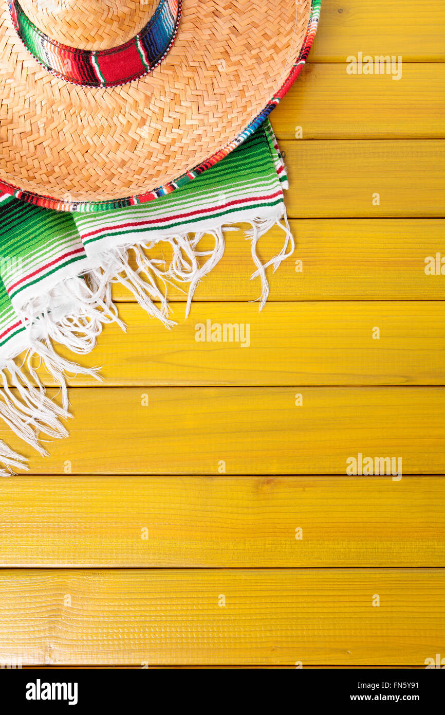 Sombrero messicano e tradizionale coperta serape prevista su un dipinto di giallo in legno di pino piano. Spazio per la copia. Foto Stock