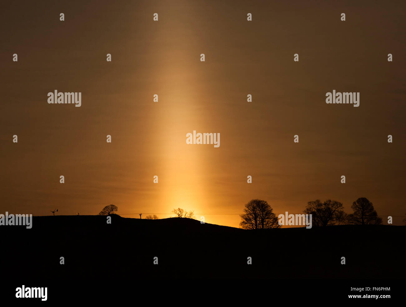 Teesdale, nella contea di Durham. Il 14 marzo 2016. Regno Unito Meteo. Un nebbioso e gelido di iniziare la giornata ha creato le condizioni per un sun pilastro intorno a sunrise questa mattina. Un pilastro di Sun è causato dalla luce solare riflesso minuscoli cristalli di ghiaccio in sospensione nell'atmosfera. Credito: David Forster/Alamy Live News Foto Stock