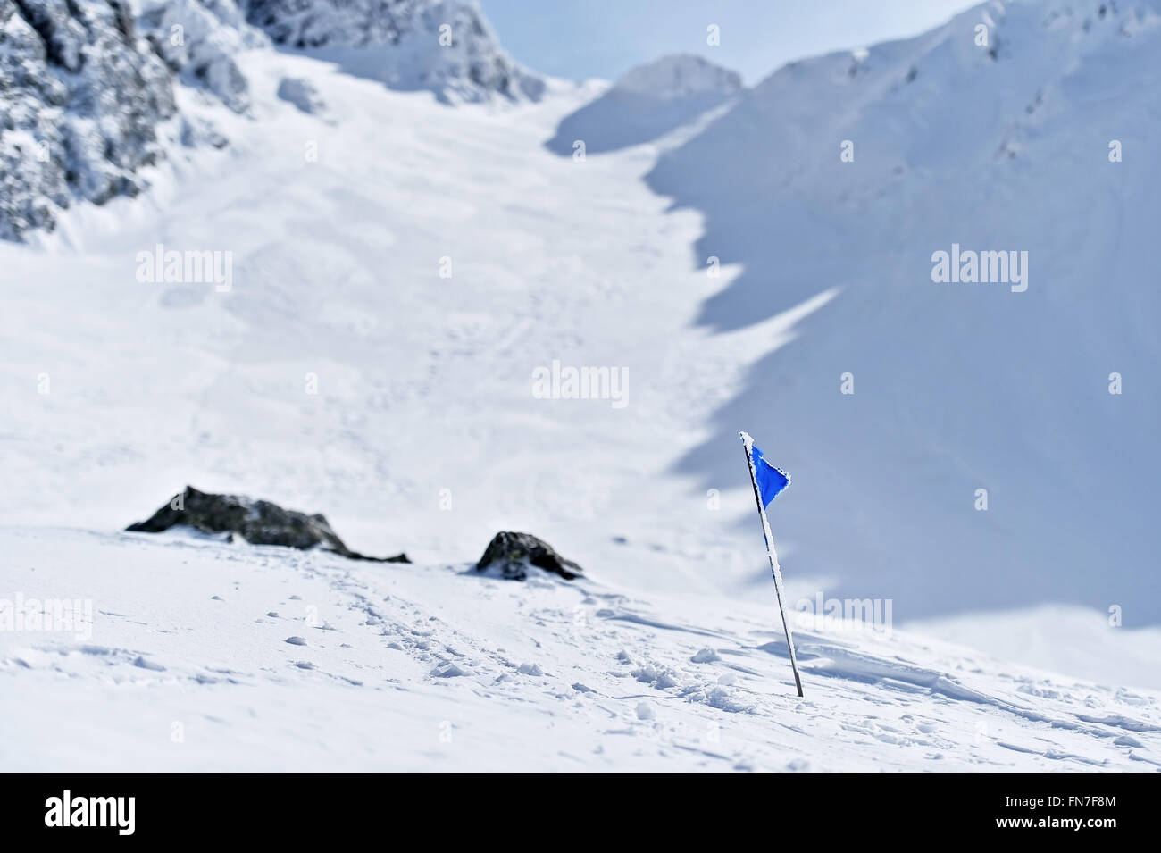 Bandiera Blu soffiata dal vento su una montagna in inverno Foto Stock
