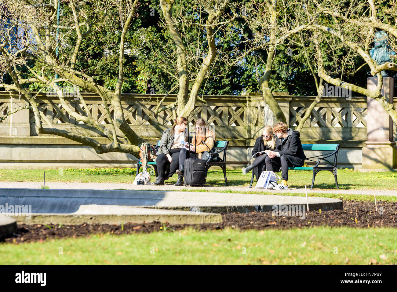 Lund, Svezia - 12 Marzo 2016: Sconosciuto giovani adulti seduti su una panchina nel parco mentre guarda il Depliant o cataloghi. L'uni Foto Stock