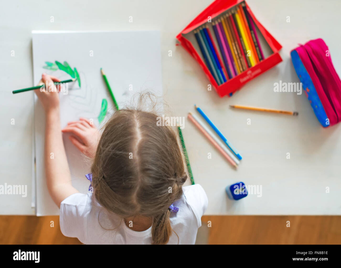 Bambina il disegno con una matita a casa. Vista dall'alto Foto stock - Alamy