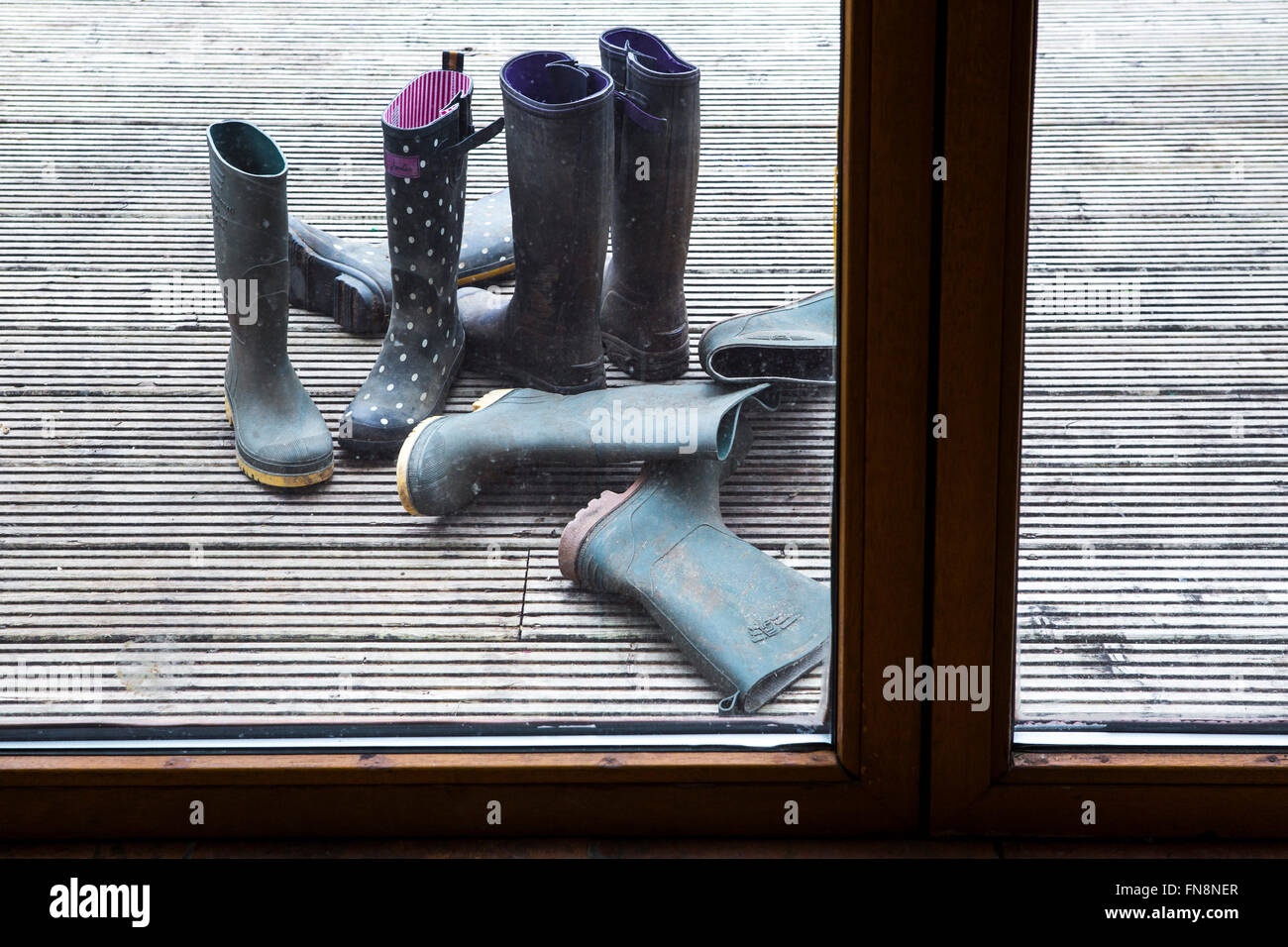 Stivali da pioggia alla porta sul retro di una casa di famiglia. Foto Stock
