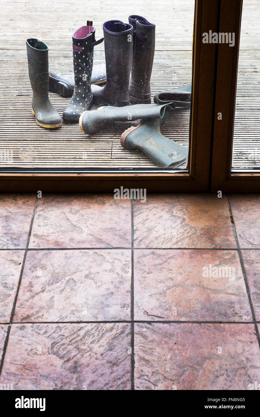 Stivali da pioggia alla porta sul retro di una casa di famiglia. Foto Stock
