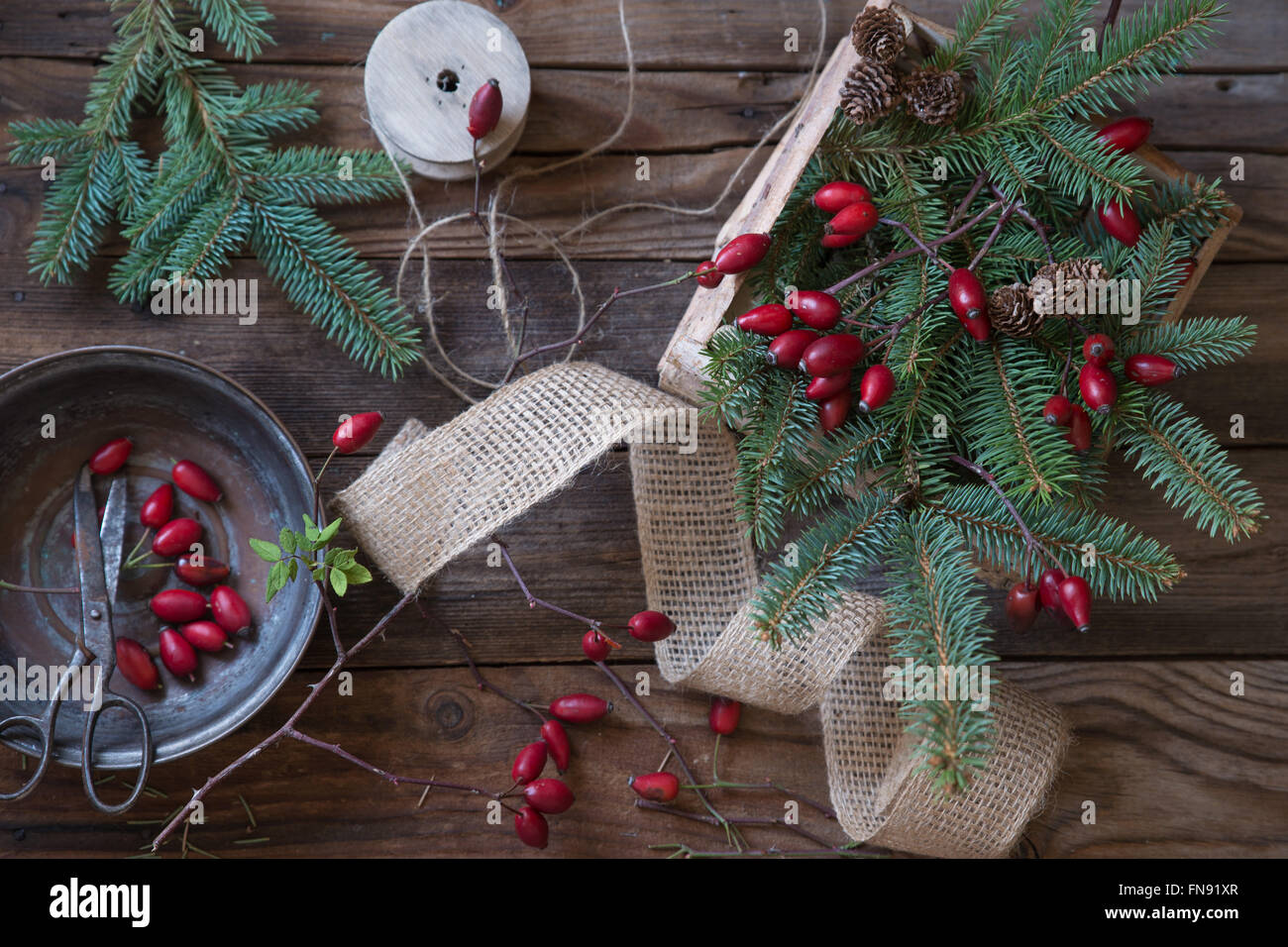 Rosella, rami di abete, nastro e corda per la realizzazione di decorazioni natalizie Foto Stock