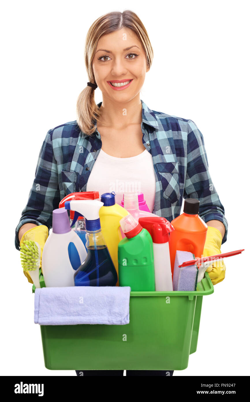 Colpo verticale di un allegro giovane donna tenendo un secchio pieno di prodotti per la pulizia e attrezzature isolati su sfondo bianco Foto Stock