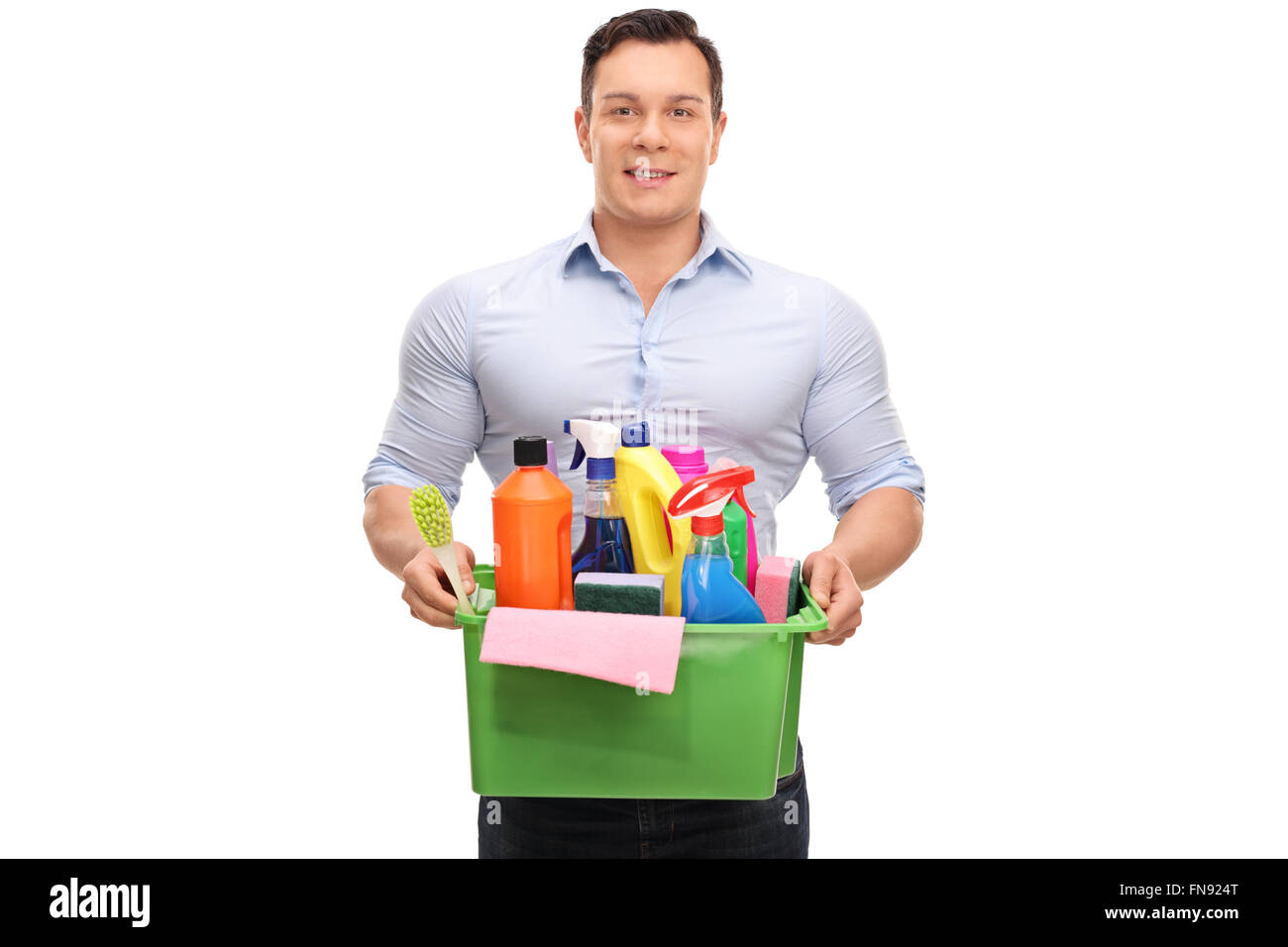 Giovane uomo tenendo un secchio di plastica pieno di prodotti per la pulizia e attrezzature isolati su sfondo bianco Foto Stock
