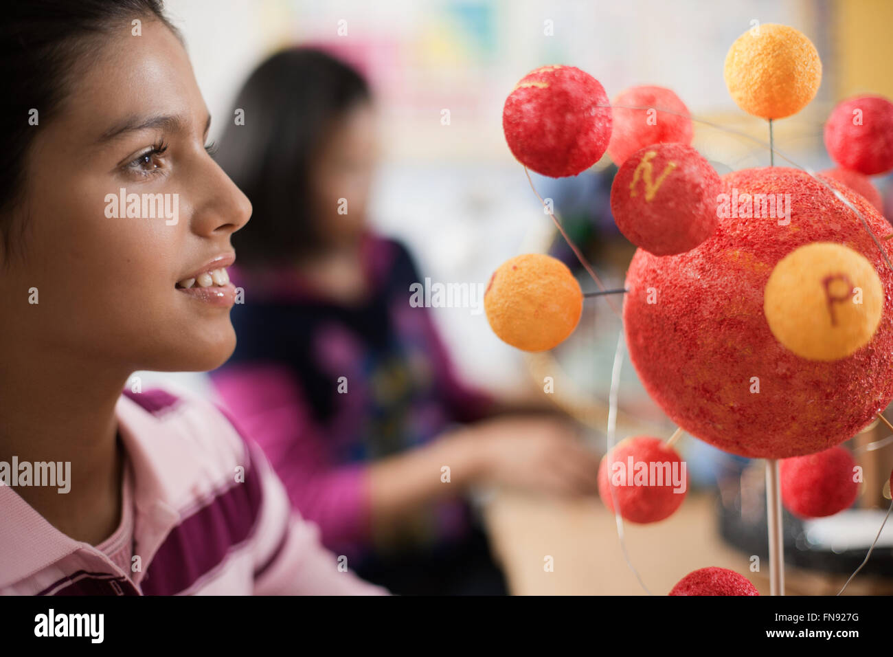 Un gruppo di studenti intorno a un tavolo in una lezione di scienze, creazione di modelli molecolari. Foto Stock