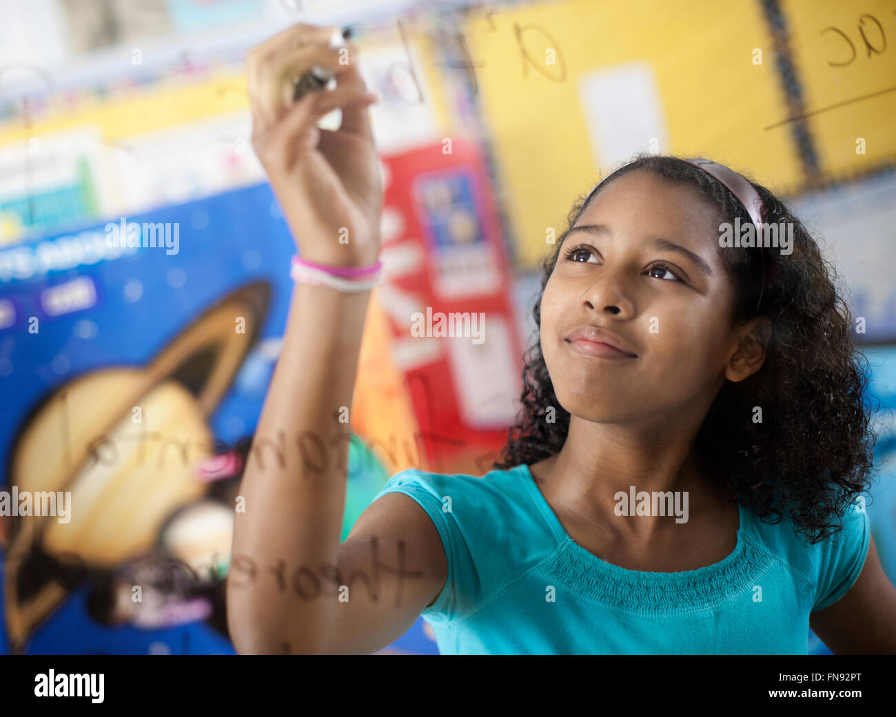 Una ragazza di scrivere con una penna su un bordo di equazioni e formule in aula. Foto Stock