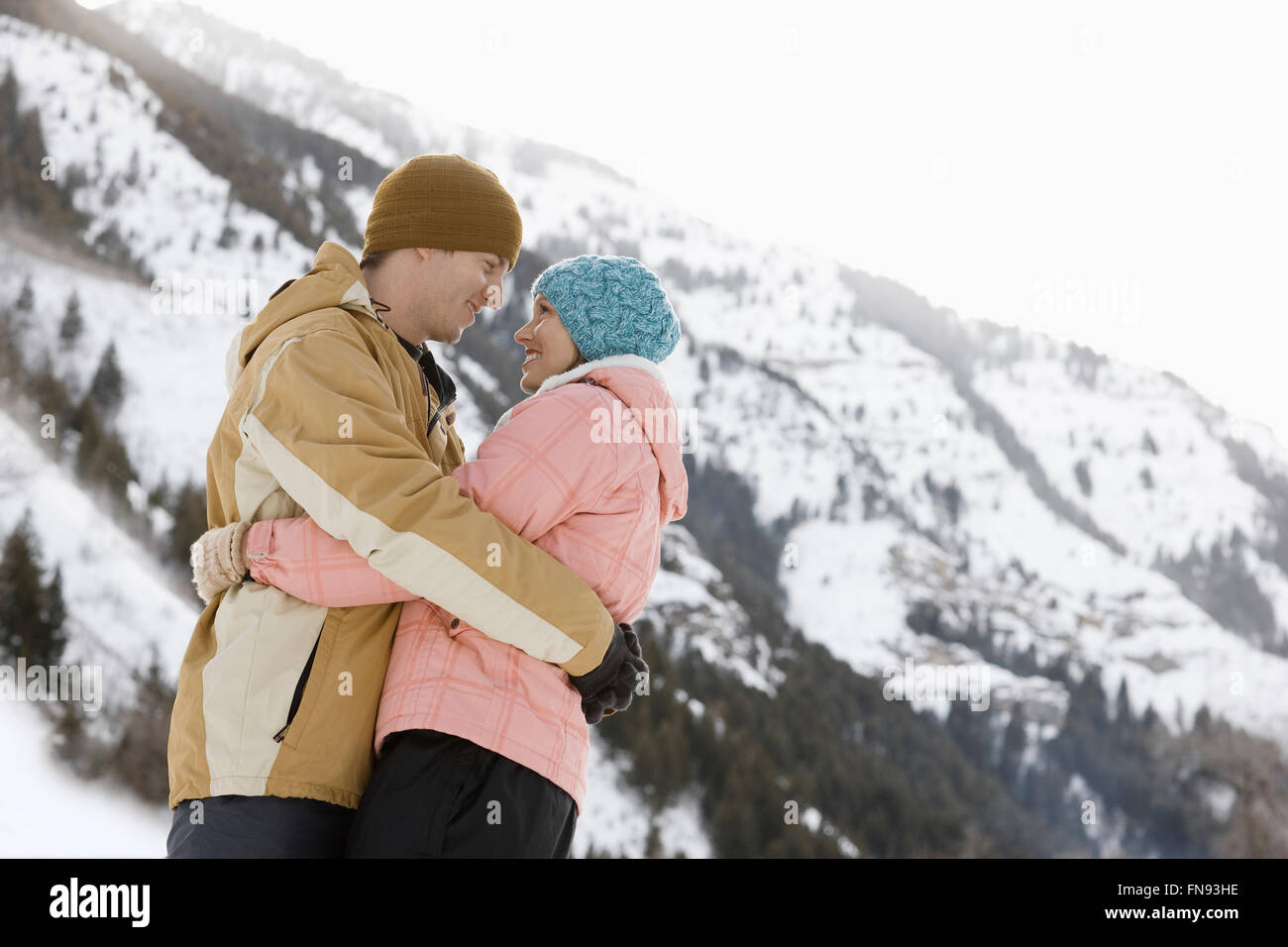 Una coppia di uomo e donna nel bel mezzo delle montagne innevate. Foto Stock