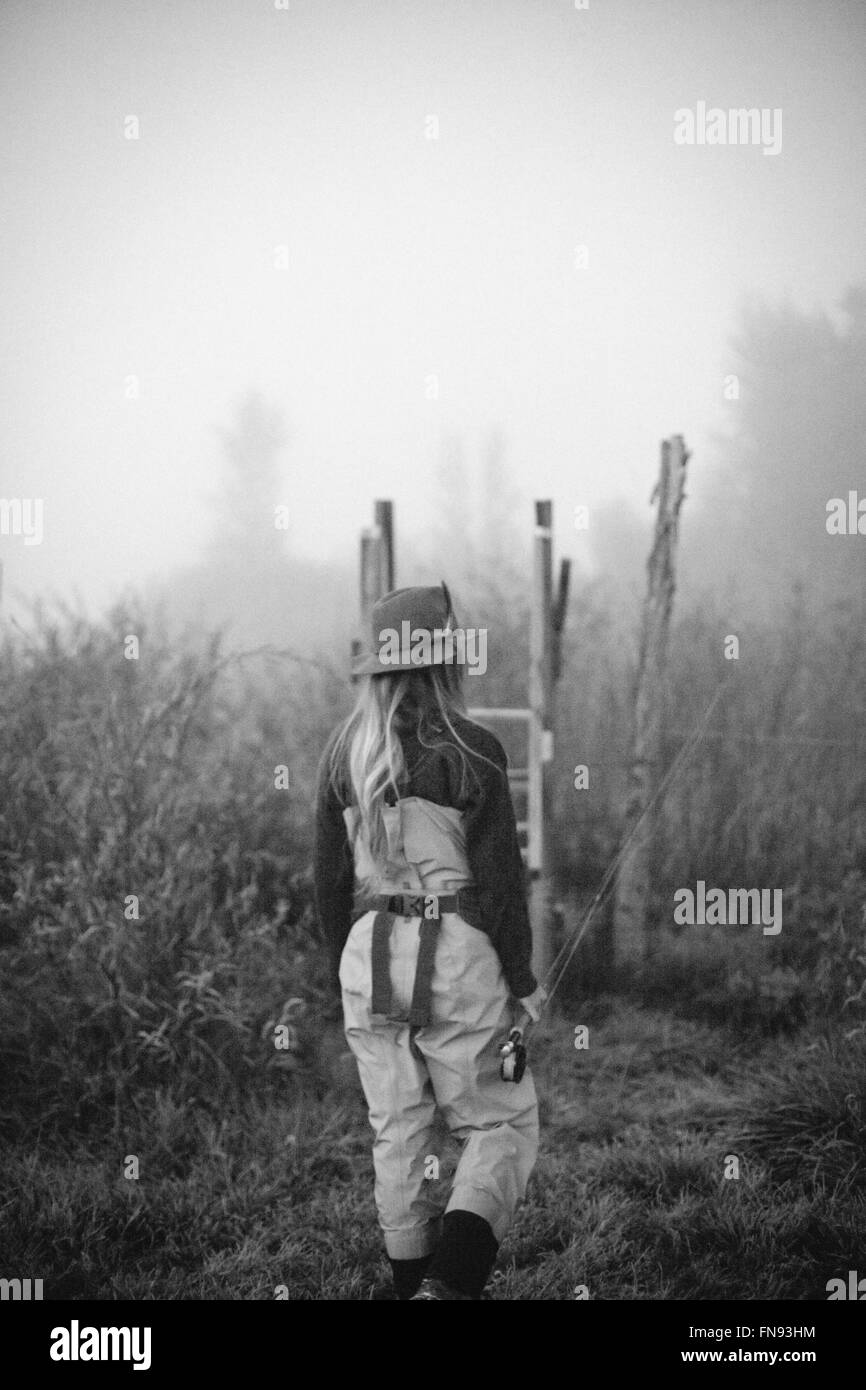 Una donna in piedi su una tavola di legno stile nella nebbia. Foto Stock