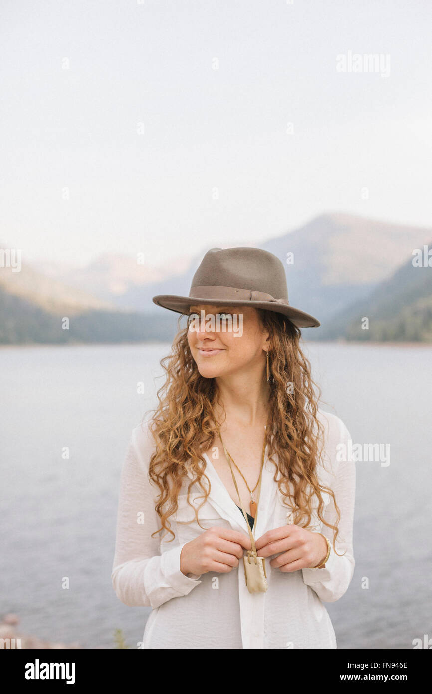 Una donna in una vasta colmato hat da un lago di montagna. Foto Stock