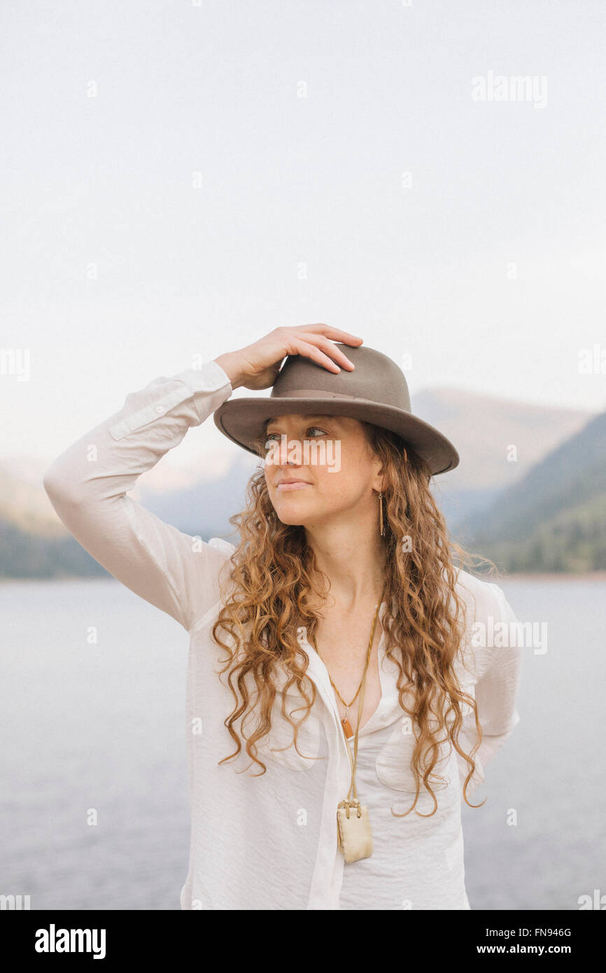 Una donna in una vasta colmato hat da un lago di montagna. Foto Stock