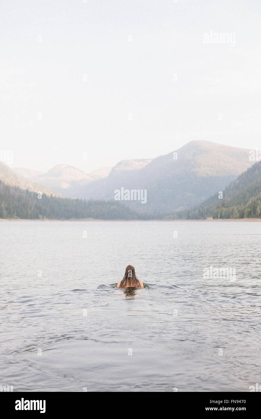 Una donna di nuotare nelle acque di un lago. Foto Stock