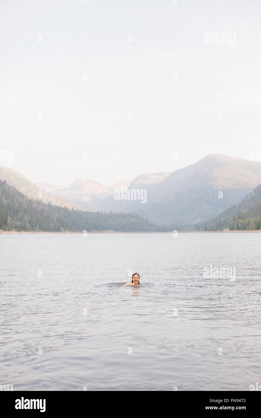 Una donna di nuotare nelle acque di un lago. Foto Stock