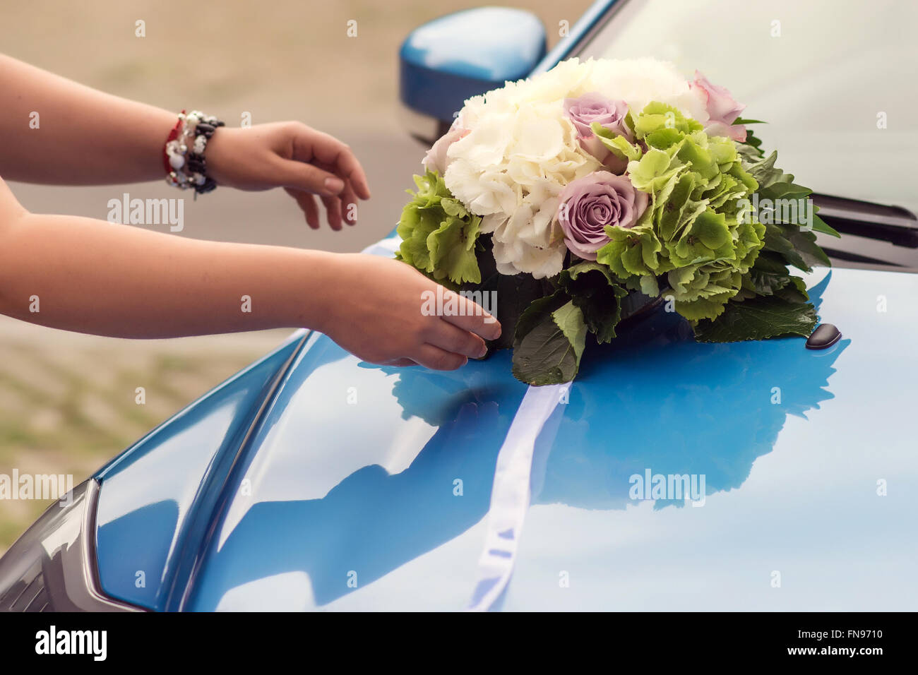 Bouquet di nozze su un cofano per auto Foto Stock