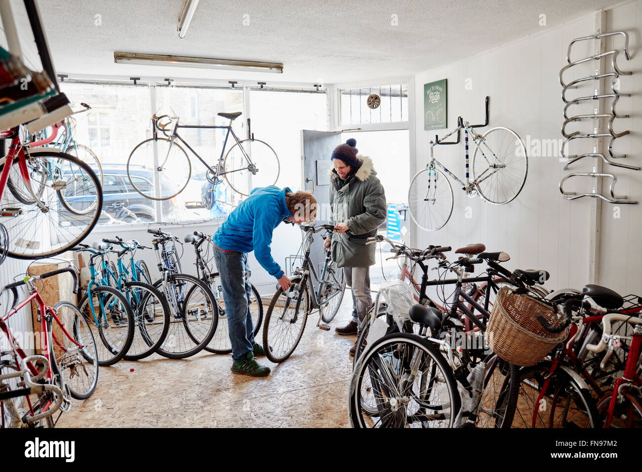Due giovani uomini in un ciclo shop, parlando. Foto Stock
