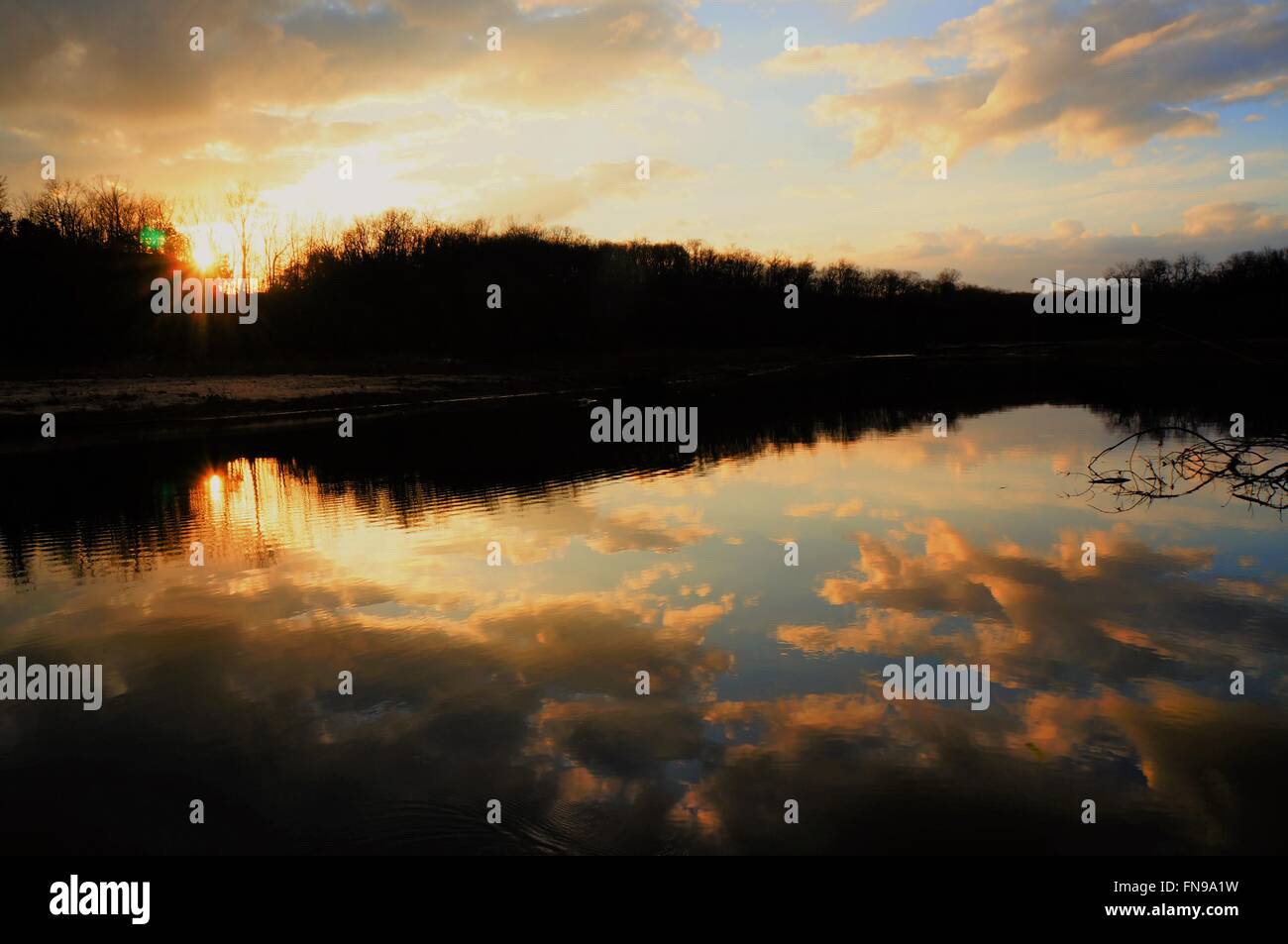 La pesca con il tramonto, acqua, cielo, alberi, il bianco delle nuvole, la terra incontra il cielo, energia, amore, felice, chiarezza, riflessioni, di pace, di gioia Foto Stock