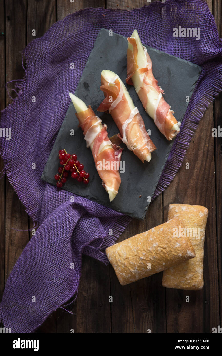 Melone avvolti nel prosciutto di Parma con pane Foto Stock