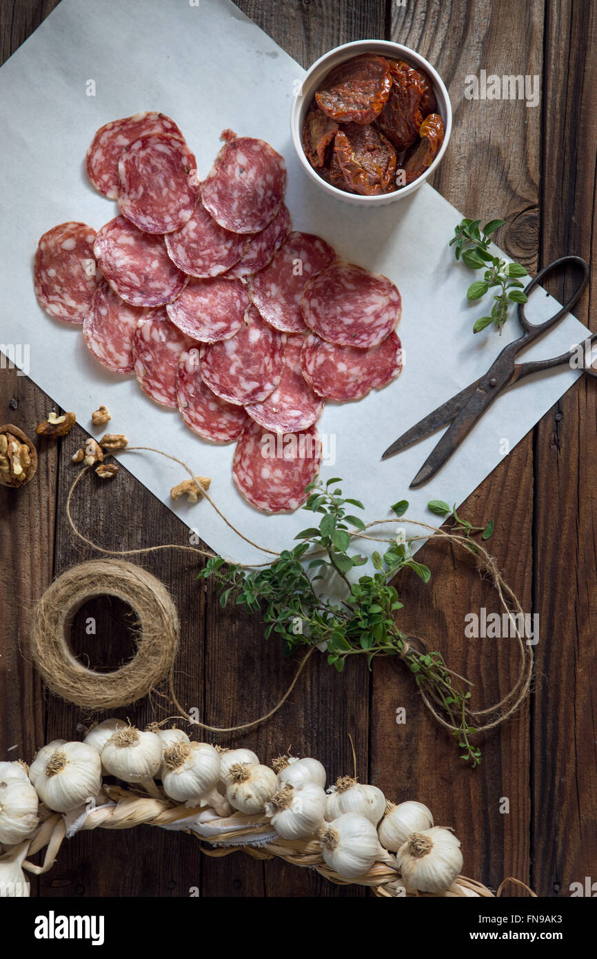 Fette di salame, aglio, pomodori secchi e erbe aromatiche Foto Stock