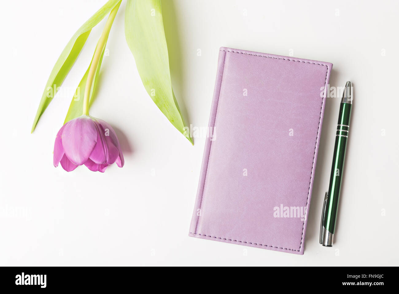 Notebook chiuso con penna e fiore, laici piatta Foto Stock