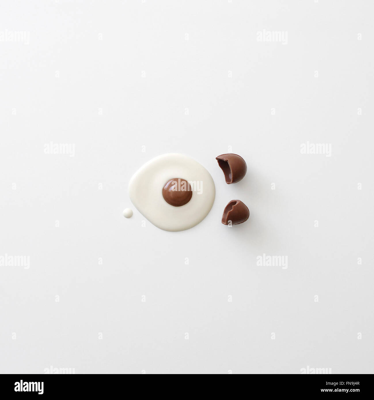 Concettuale uova incrinate in bianco e di cioccolato al latte Foto Stock