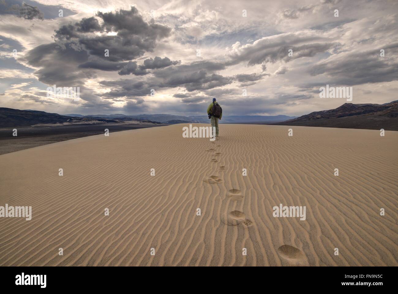 Uomo che cammina nelle dune di eureka, Death Valley National Park, California, Stati Uniti Foto Stock