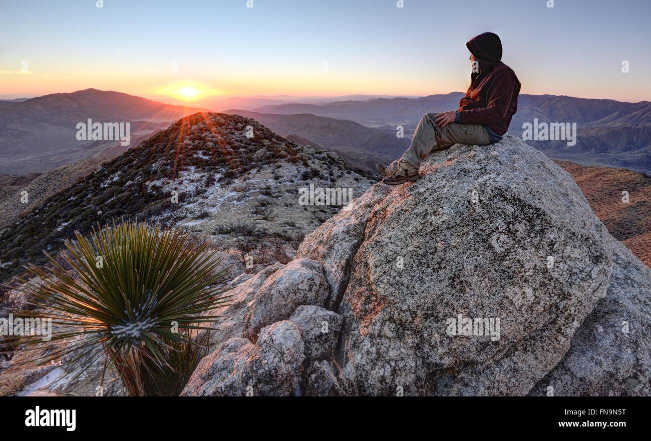 Uomo seduto sul picco di granito, Anza-Borrego Desert State Park, California, Stati Uniti d'America Foto Stock