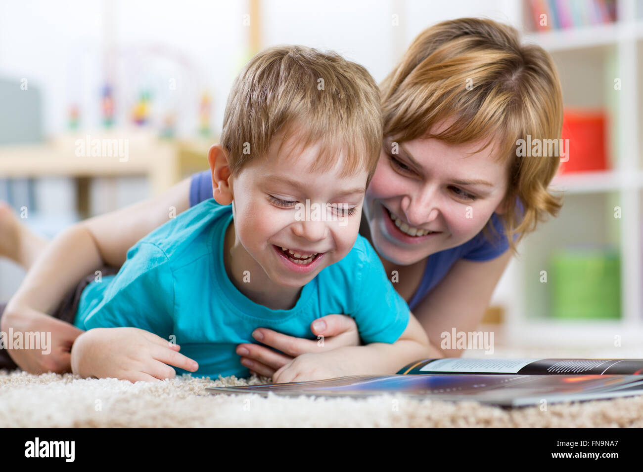 Madre la lettura di un libro di suo figlio Foto Stock