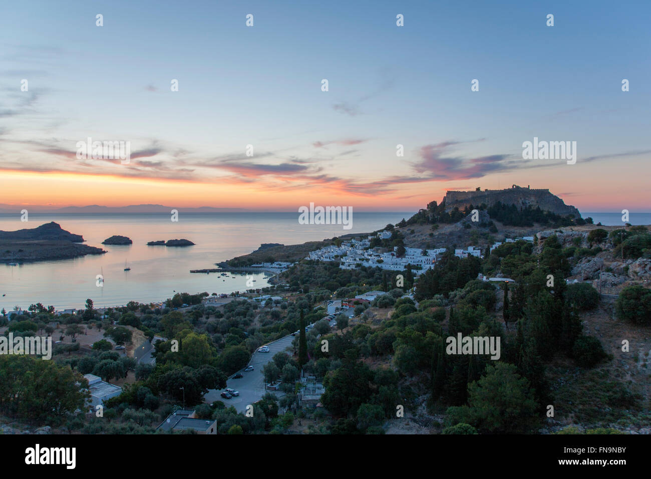 Lindos, Rodi, Egeo Meridionale, Grecia. Vista dalla collina per il villaggio e di Acropolis, alba. Foto Stock