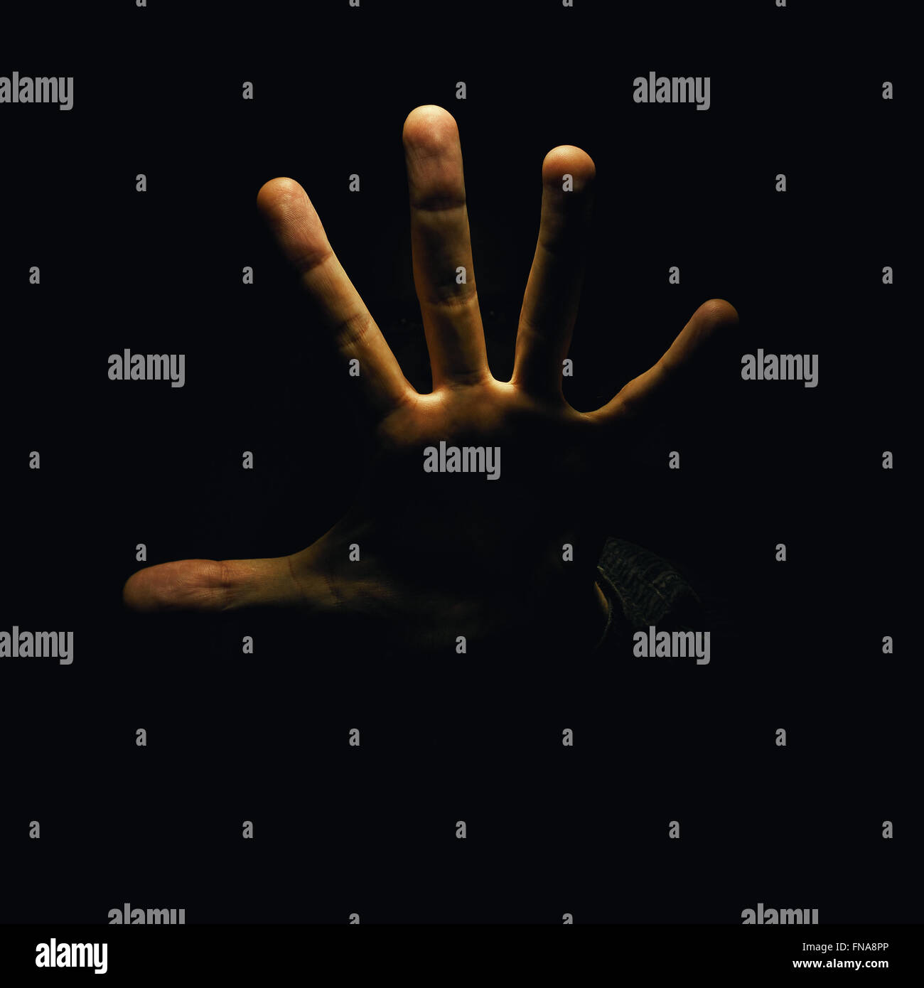 Basta una mano aperta e due lo sguardo dell'uomo può essere visto nel buio. Foto Stock
