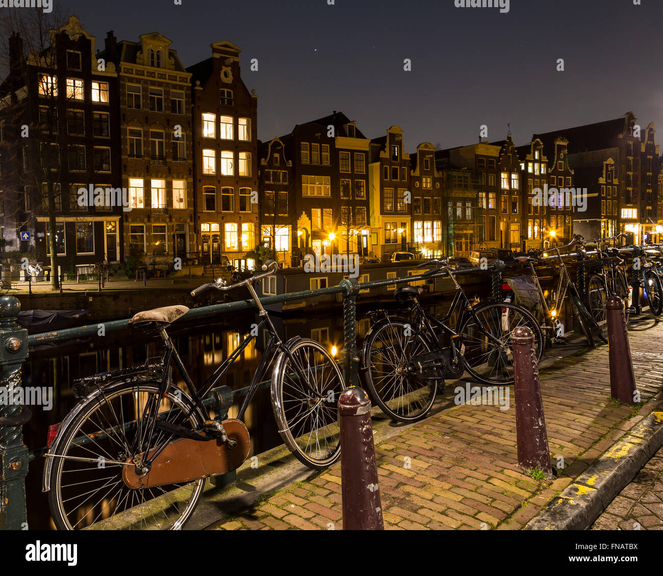 Bike incatenati a ringhiera lungo i canali di Amsterdam. Gli edifici possono essere visti sullo sfondo. Vi è spazio per il testo. Foto Stock