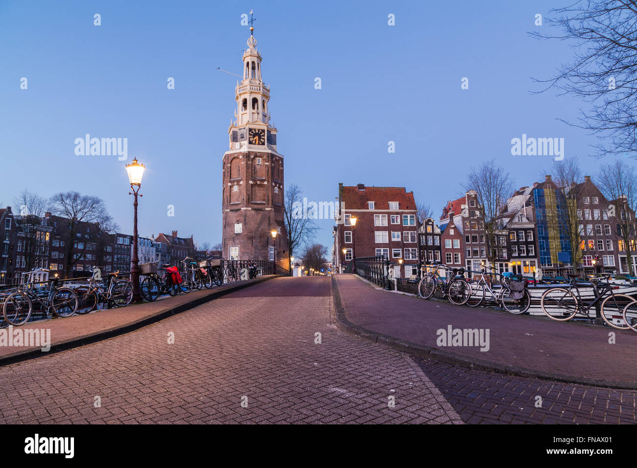 Una vista lungo Oudeschans Street verso la Torre Montelbaanstoren ad Amsterdam al crepuscolo. Costruzione di barche e biciclette possono essere vedere Foto Stock