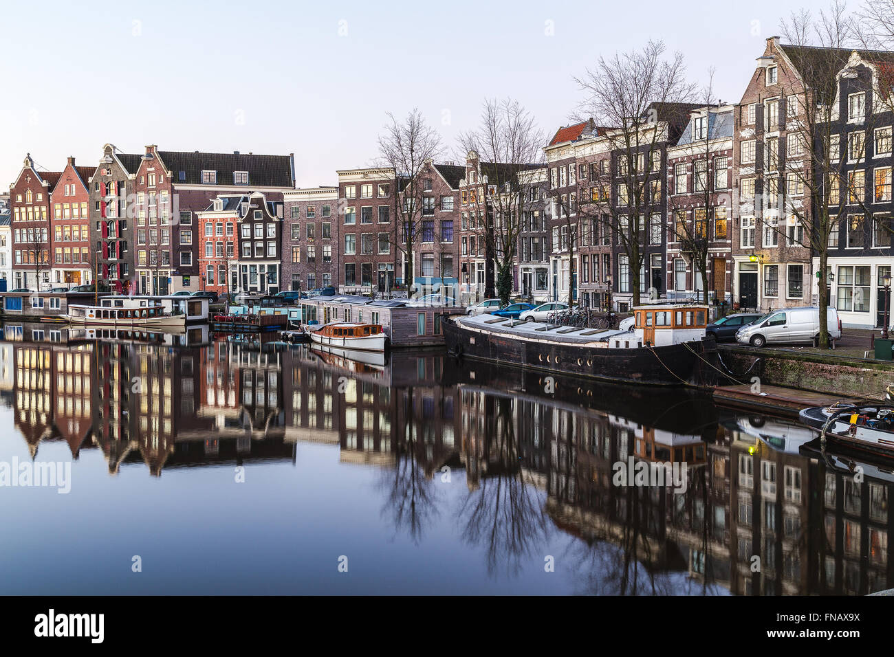 Una vista lungo il canale Waalseilandgracht ad Amsterdam la mattina. Edificio, barche e riflessioni può essere visto. Foto Stock