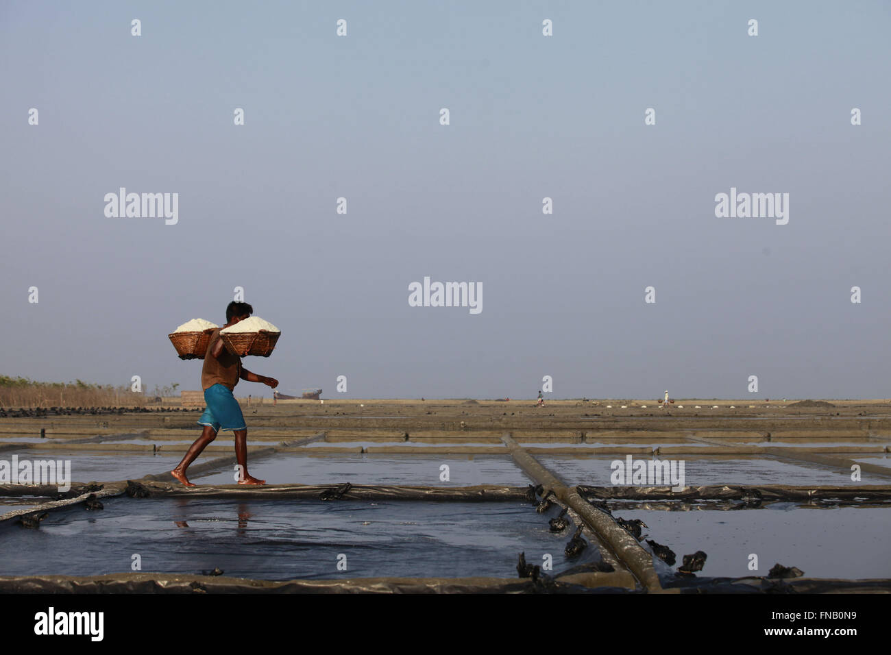 Marzo 12, 2016 - Kutubdia, Bangladesh - un uomo porta un cucchiaio di sale grezzo a Kutubdia, circa 400 chilometri di distanza da Dacca in Bangladesh. (Credito Immagine: © Suvra Kanti Das via ZUMA filo) Foto Stock