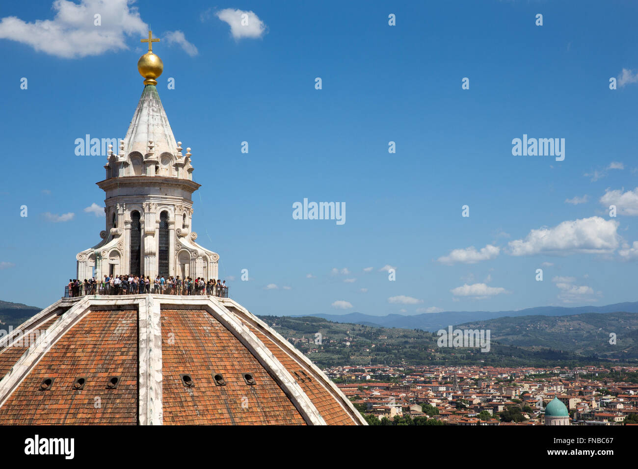 I turisti in piedi in cima della cupola del Brunelleschi del Duomo di Firenze in Italia che si affaccia sulla città e la campagna toscana. Foto Stock