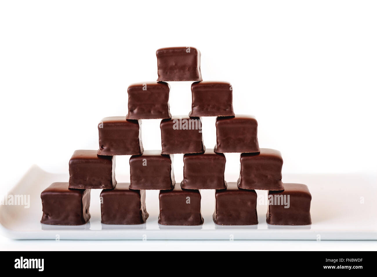 Piramide costituita da file di tartufi di cioccolato su un colore bianco porcellana piastra. Foto Stock
