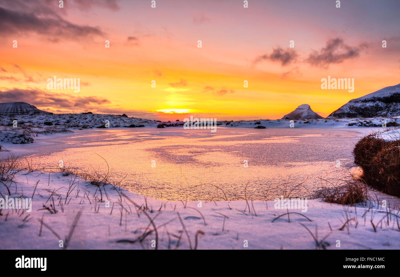 Serata fantastica paesaggio incandescente dalla luce del sole. Drammatica scena invernale. La neve e il tramonto. Isole Faerøer, Danimarca,l'Europa Foto Stock