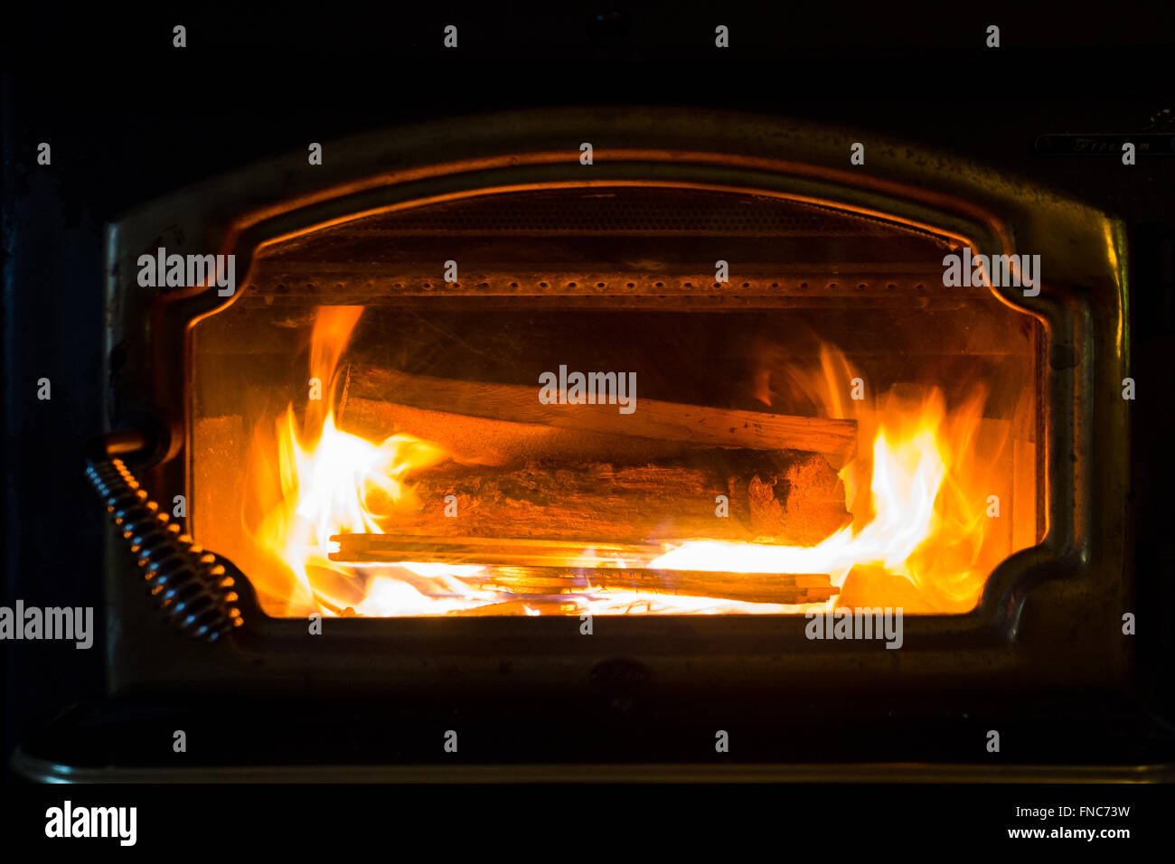 La combustione di legna in un camino in inverno con fiamme di colore arancione. Foto Stock