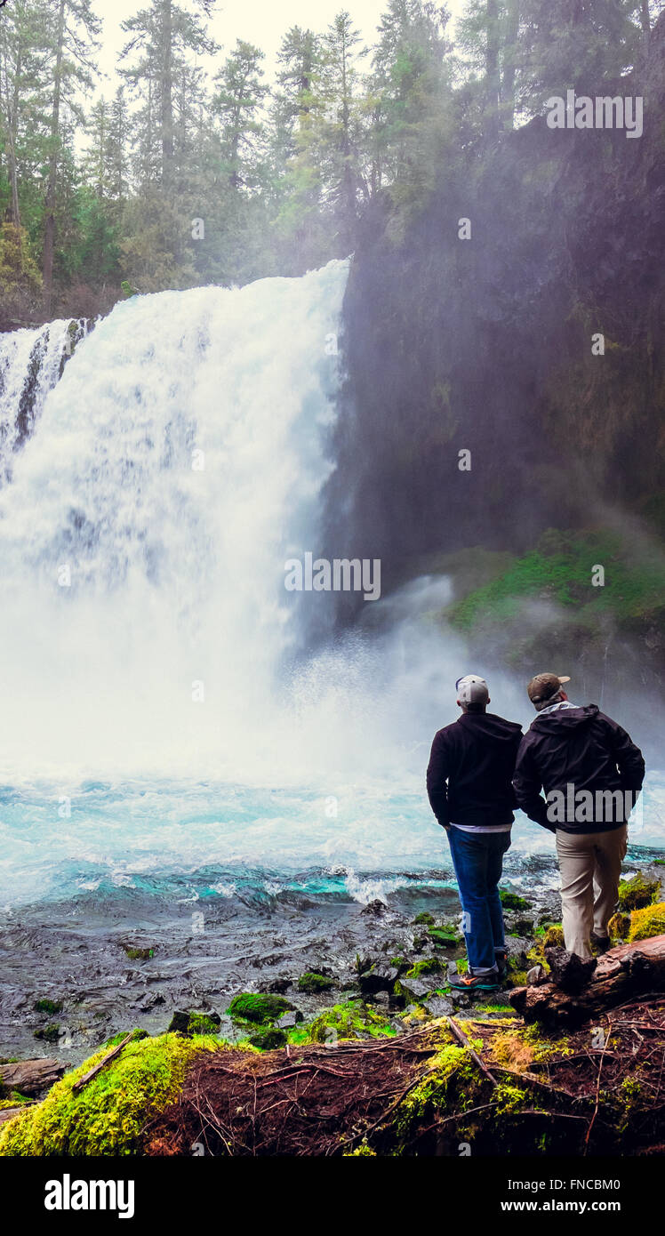 Due uomini esplorare Koosah Falls in Oregon lungo lo storico fiume McKenzie. Foto Stock