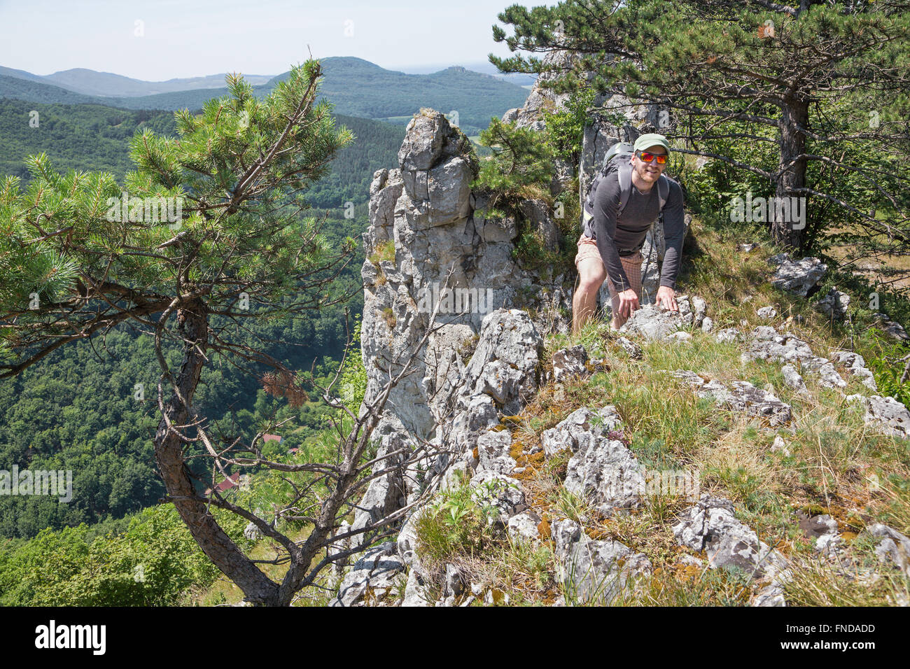 L'uomo sulla sommità della roccia di trekking Foto Stock