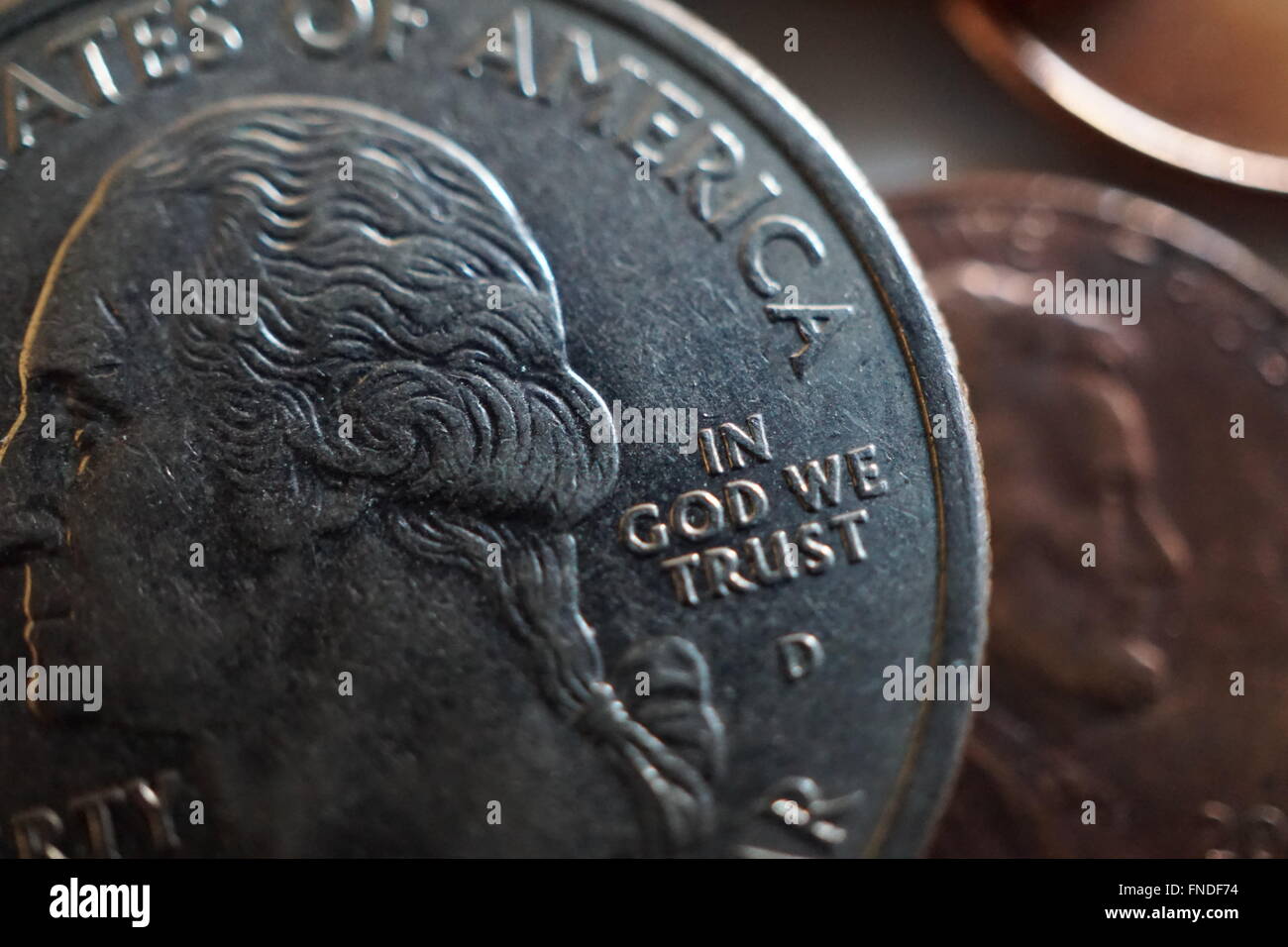 Primo piano della In God We Trust iscrizione su un quarto posto alla sommità di un centesimo Foto Stock