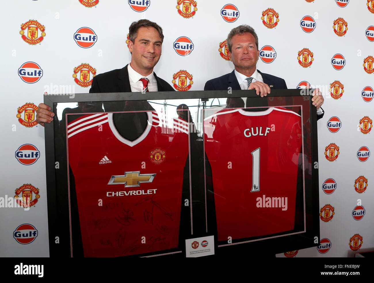 (160315) -- MANCHESTER, Marzo. 15, 2016 (Xinhua) -- Manchester United Direttore Commerciale Jamie Reigle (L) e il petrolio del Golfo International Vice presidente Frank Rutten scambio di doni durante la conferenza spress a Manchester slegato dal Club della massa di formazione a Manchester in Gran Bretagna il 14 marzo 2016. Premier League inglese lato Manchester United qui il lunedì ha annunciato tre anni di partenariato globale con la Gulf Oil International. Olio del golfo è diventata internazionale il Manchester United primo ufficiale mondiale di olio lubrificante e di carburante del partner retail. (Xinhua/Han Yan) Foto Stock