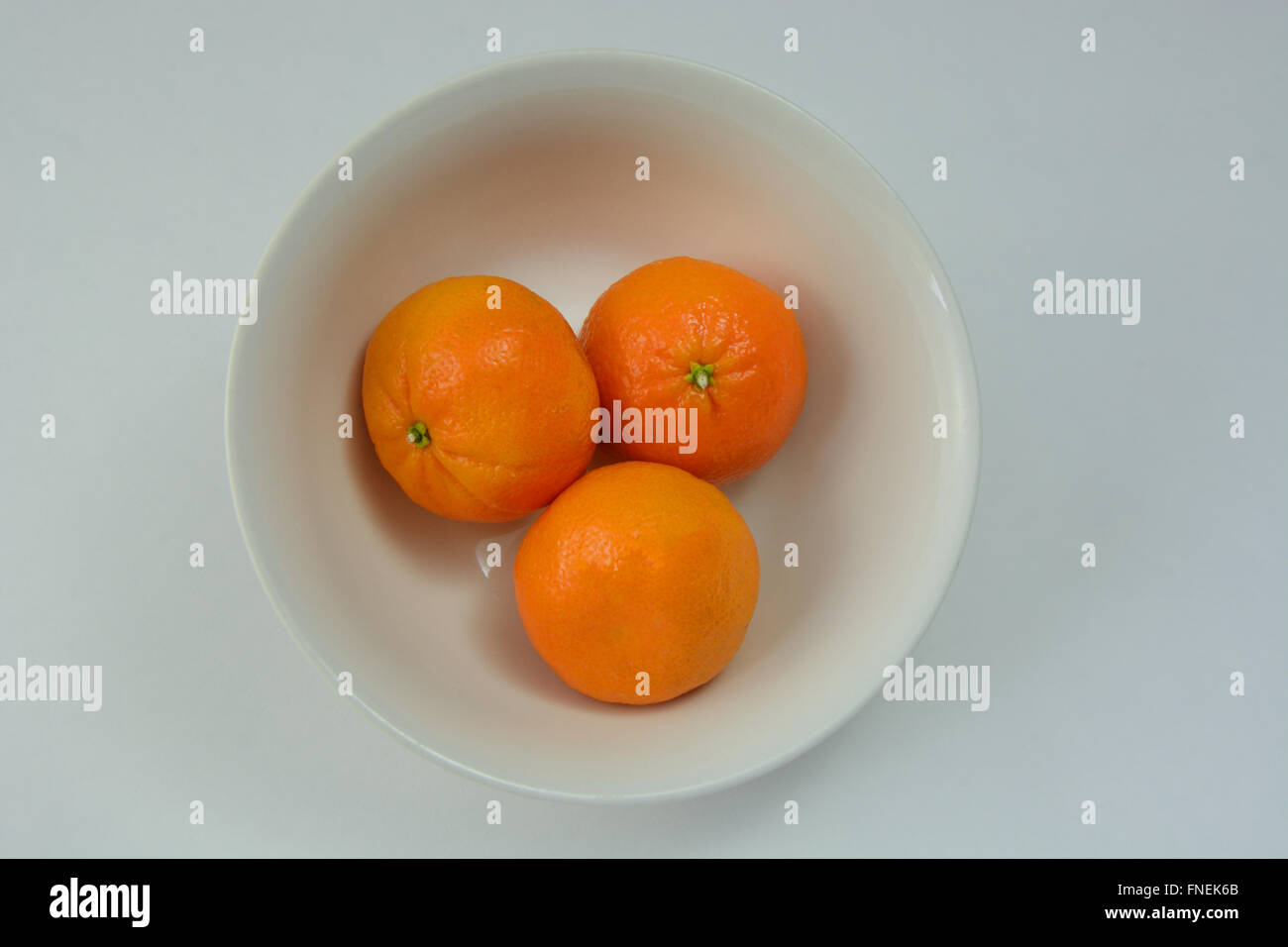 Tre mandarini arance nel recipiente Foto Stock