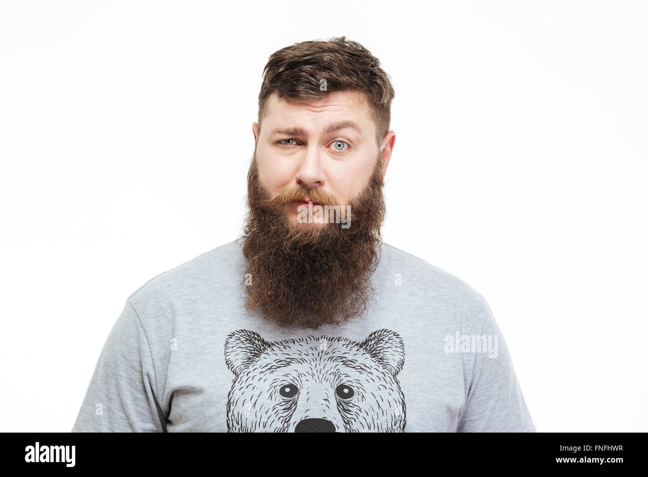 Ritratto di confuso uomo bello con la barba guardando la fotocamera su sfondo bianco Foto Stock