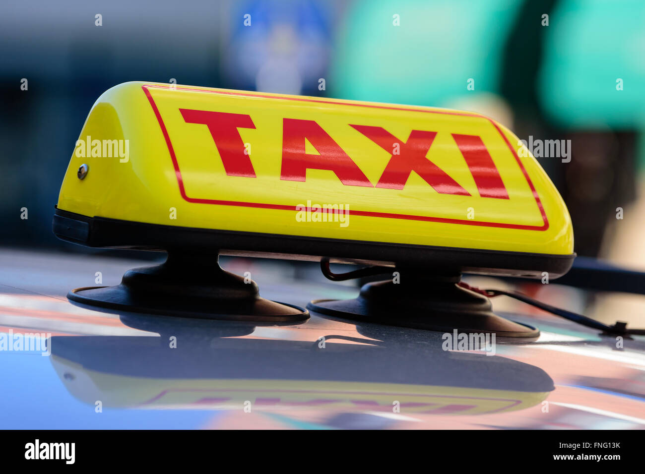 Un giallo e rosso segno di taxi sulla parte superiore di un'auto. Il segno è attaccata al tetto della vettura con ventose. Foto Stock