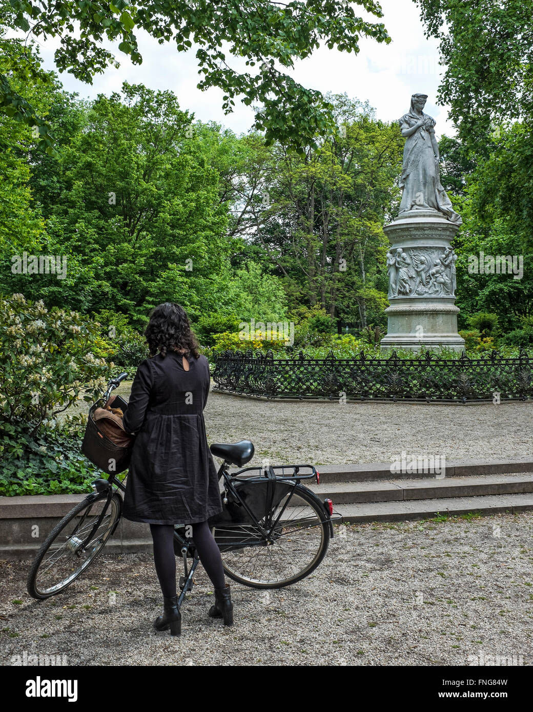 Donna in bicicletta guardando la regina Louis monumento in pubblico Tiergarten park in estate, Berlino Foto Stock