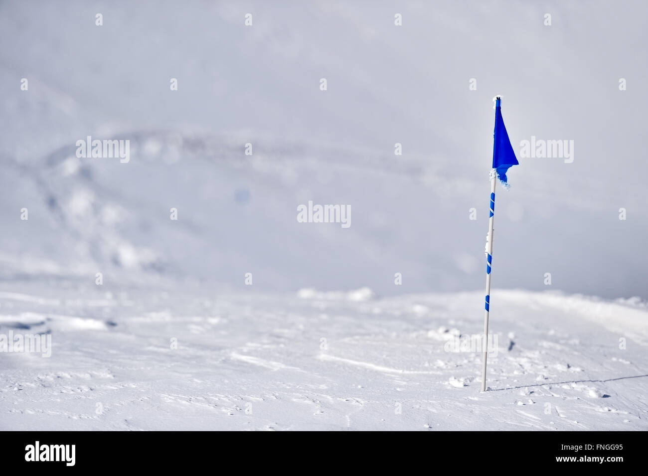 Bandiera Blu soffiata dal vento su una montagna in inverno Foto Stock