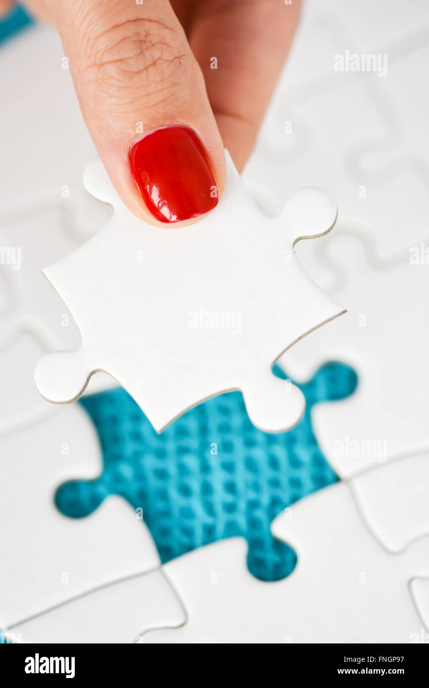 Donna raccordo di mano destra pezzo del puzzle suggerendo di business networking concept Foto Stock