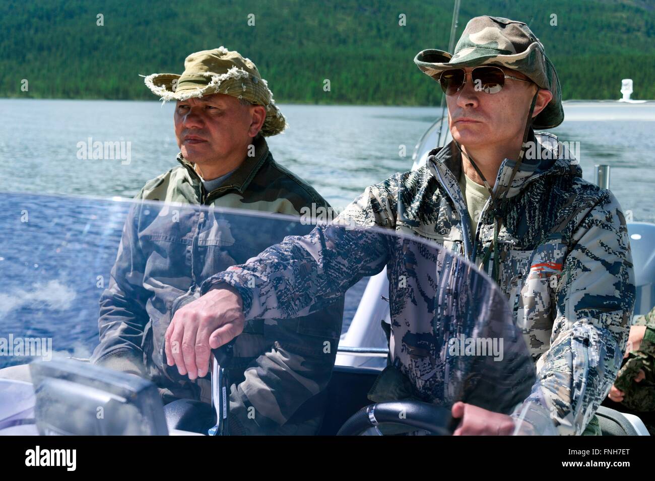 Il presidente russo Vladimir Putin a fianco il Ministro della difesa Sergei Shoigu pilota di una barca a motore durante una breve vacanza Luglio 20, 2013, il Siberiano Tyva regione, Russia Foto Stock